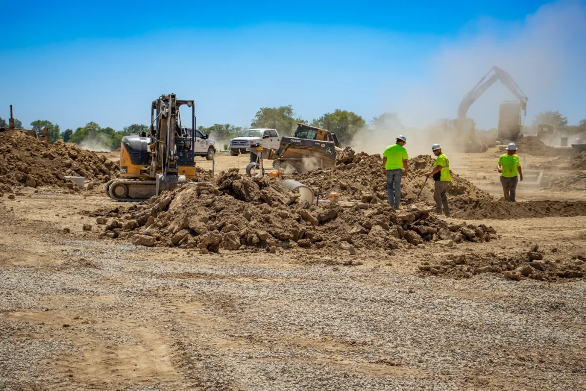 Crews grading and stabilizing soil on a commercial site